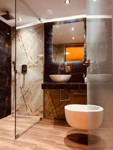 un bagno con vasca, lavandino e specchio di Marble House a Kavala