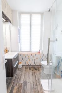 y baño con bañera, lavabo y aseo. en Charmant T2 au pied du château, en Amboise