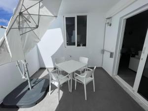ein Balkon mit Tisch und Stühlen und einem Sonnenschirm in der Unterkunft White Serenity in Playa Honda