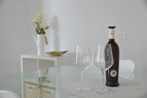 eine Flasche Wein und zwei Weingläser auf einem Tisch in der Unterkunft White Serenity in Playa Honda + 40 Fotos