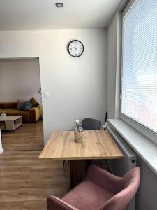 une chambre avec une table et une horloge sur le mur dans l'établissement Modern Central Apartment, à Nitra