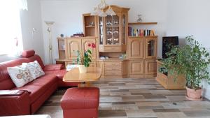 a living room with a red couch and a wooden cabinet at Ferienwohnung Mioritza in Kallmünz