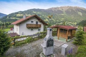 a house in the mountains with a monument in front of it at Haus Montanara myRelaxs in Tschagguns