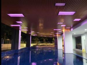 einem Pool in einem Gebäude mit lila Leuchten in der Unterkunft The Ximplicity @ Venus Residence Sitiawan Manjung in Sitiawan + 10 Fotos