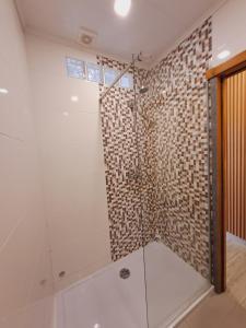 a bathroom with a shower with a glass door at Casa do Castelo in Tomar