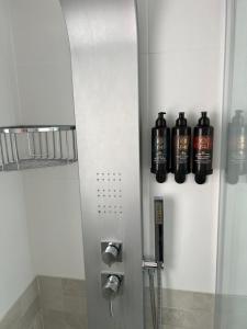 drei Flaschen Alkohol sind an der Wand eines Badezimmers. in der Unterkunft Hotel Bella Dolores in Lloret de Mar