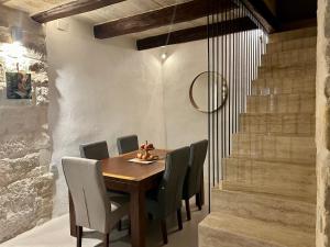 comedor con mesa de madera y sillas en Traditional House of Character with Terrace - Central, Cozy & Calm en Birkirkara