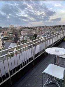 Luxury Top Floor Penthouse Apartment near Heathrow في لندن: بلكونه مع طاوله واطلاله على مدينه