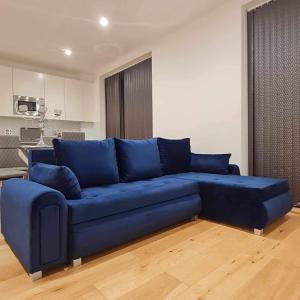 a large blue couch in a living room at Luxury Top Floor Penthouse Apartment near Heathrow in London