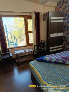 1 dormitorio con cama, ventana y mesa en Joshi Holiday Home Stay, en Lansdowne