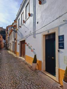 a cobblestone street with a building with a blue door at Casa do Castelo in Tomar