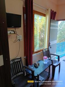 Habitación con mesa, 2 sillas y ventana en Joshi Holiday Home Stay, en Lansdowne