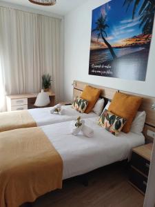 dwa łóżka w pokoju hotelowym z obrazem na ścianie w obiekcie Ventura Premium w Alicante