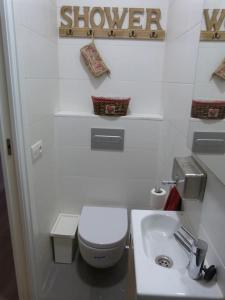 ein weißes Bad mit einem WC und einem Waschbecken in der Unterkunft SAGRADA FAMILIA- Centric Apartment in Barcelona