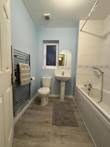 a bathroom with a toilet and a sink and a tub at Meadow View in Elstow