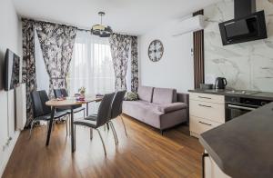 uma cozinha e sala de estar com uma mesa e um sofá em Apartament 32 em Gąski