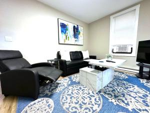 uma sala de estar com mobiliário preto e um tapete azul em Cozy unit King bed & laundry em Wilmington