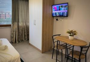 um pequeno quarto com uma mesa e uma televisão na parede em Sea View Apartments em Golem