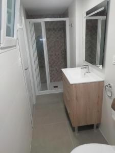 a white bathroom with a sink and a shower at casa de tres habitaciones con parking bajo la casa in Villajoyosa