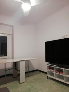 ein Wohnzimmer mit einem TV und einem Tisch mit einem TV in der Unterkunft casa de tres habitaciones con parking bajo la casa in Villajoyosa