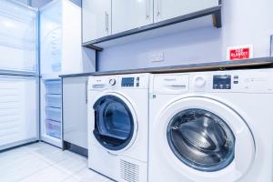 a white washer and dryer in a laundry room at Simba Stays - Contractors, Relocators , Families, Wi-Fi, Free Parking in Hemel Hempstead
