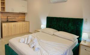 um quarto com uma cama com toalhas enroladas em Sea View Apartments em Golem