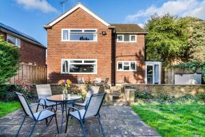 a patio with a table and chairs in front of a house at Simba Stays - Contractors, Relocators , Families, Wi-Fi, Free Parking in Hemel Hempstead