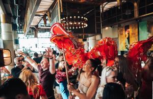 a crowd of people holding red flags at a party at FIVE Palm Jumeirah Dubai in Dubai