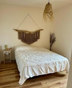 1 dormitorio con 1 cama con edredón blanco en Casa Tela Marinera, en Cotillo