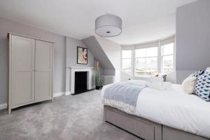 una camera bianca con un grande letto e un camino di Dragon Suites - City Centre Castle View 1 Bed Apartment a Edimburgo
