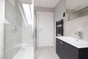 e bagno con doccia, lavandino e vasca. di Dragon Suites - City Centre Castle View 1 Bed Apartment a Edimburgo