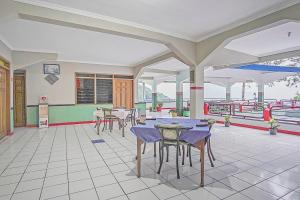 - Zona de comedor con mesas y sillas en un edificio en OYO 90132 Lie Mas Hotel en Pasuruan