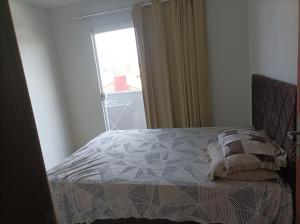 1 dormitorio con 1 cama y una ventana con en AP Beira mar, en Laranjal