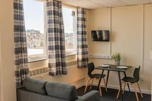 プリマスにあるSuperior Sea View Apartment 5のテーブルとソファと窓のあるリビングルーム