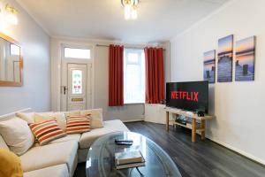 a living room with a white couch and a television at Unique 2BR House - Free Parking and Stunning Living Room in Nottingham