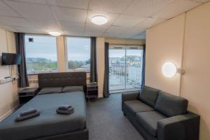 プリマスにあるSuperior Sea View Apartment 5のベッド、ソファ、椅子が備わる客室です。