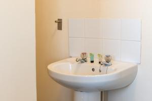 プリマスにあるSuperior Sea View Apartment 5の鏡付きの浴室の白い洗面台 +11枚の写真