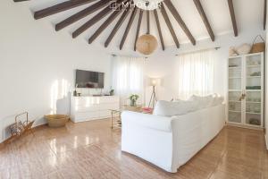 uma sala de estar com um sofá branco e uma televisão em CASA LA MOTUCA - Calpe COSTA BLANCA em Calpe
