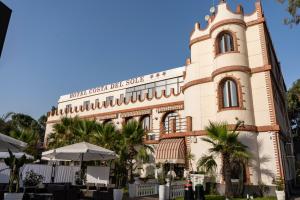 ein Gebäude mit einem Uhrturm auf der Seite in der Unterkunft Mg Palace Hotel Costa del Sole in Vaccarizzo - Delfino