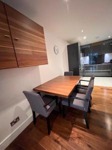 een eetkamer met een houten tafel en stoelen bij Exclusive Large Parliament Apartment in Londen