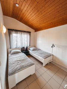 Duas camas num quarto com tecto em madeira em Pinova em Karlsruhe