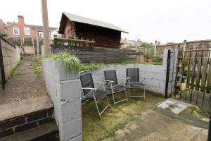 two chairs and a fence in a yard at Unique 2BR House - Free Parking and Stunning Living Room in Nottingham