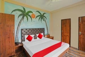 1 dormitorio con 1 cama con palmeras en la pared en OYO Flagship MH Inn en Varanasi