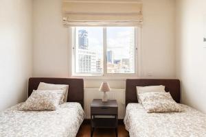 Duas camas num quarto com uma janela em Warm Residence in the heart of the City Center - Balcony & view em Nicósia