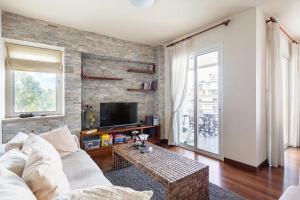 ein Wohnzimmer mit einem weißen Sofa und einer Ziegelwand in der Unterkunft Warm Residence in the heart of the City Center - Balcony & view in Nikosia