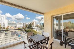 einen Balkon mit einem Tisch und Stadtblick in der Unterkunft Warm Residence in the heart of the City Center - Balcony & view in Nikosia