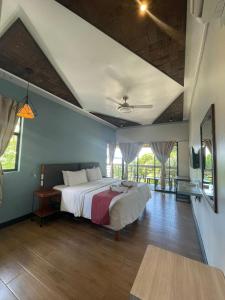 a bedroom with a large bed in a room at Bugana Beach and Dive Resort in Manlocahoc