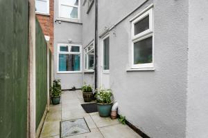 an alley with potted plants on the side of a building at Luxury 3BR House - Free Parking and Stunning Garden! in Nottingham