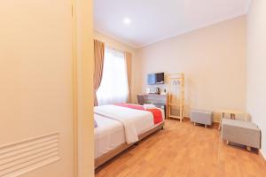 a hotel room with a bed and a window at RedDoorz Plus @ Bagusrangin Street 2 in Bandung