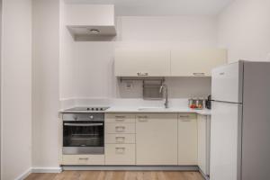 a kitchen with white cabinets and a refrigerator at Yashar Suites JLM in Jerusalem